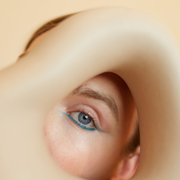 Retrato editorial artístico con ojo azul y maquillaje suave, fotografía de moda de Elisabet Encina