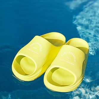 Chanclas amarillas sobre agua de piscina